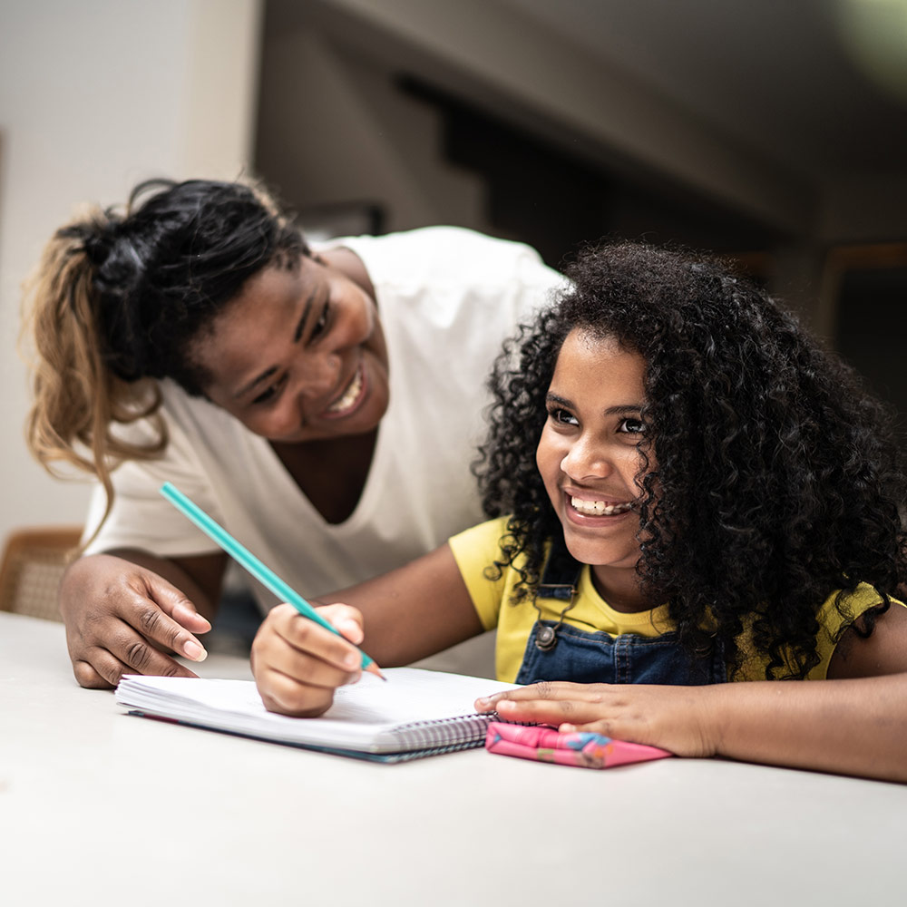 woman helping young girl with homework